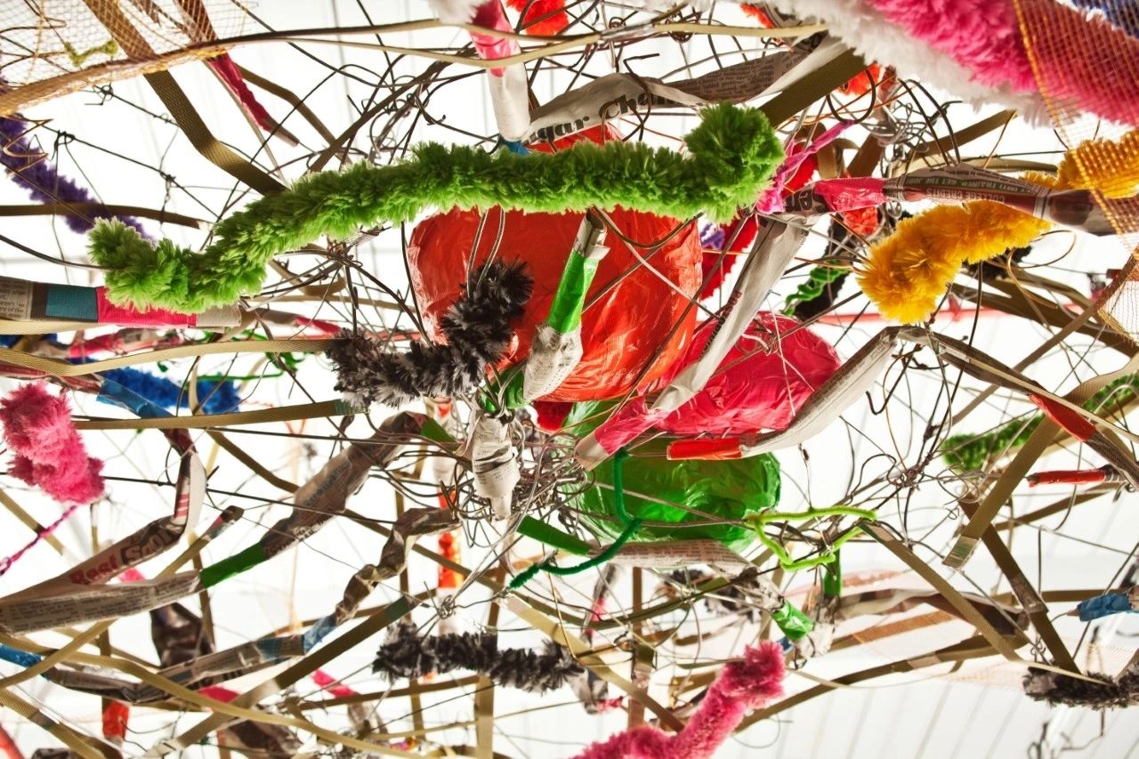A close up of some branches with colorful yarn