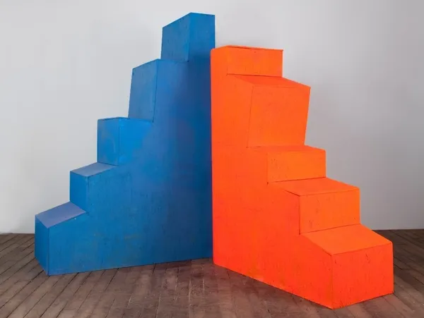 A blue and orange staircase in the corner of a room.