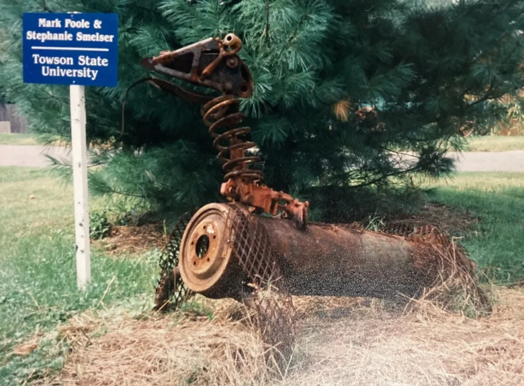 A cross is shown in front of trees.