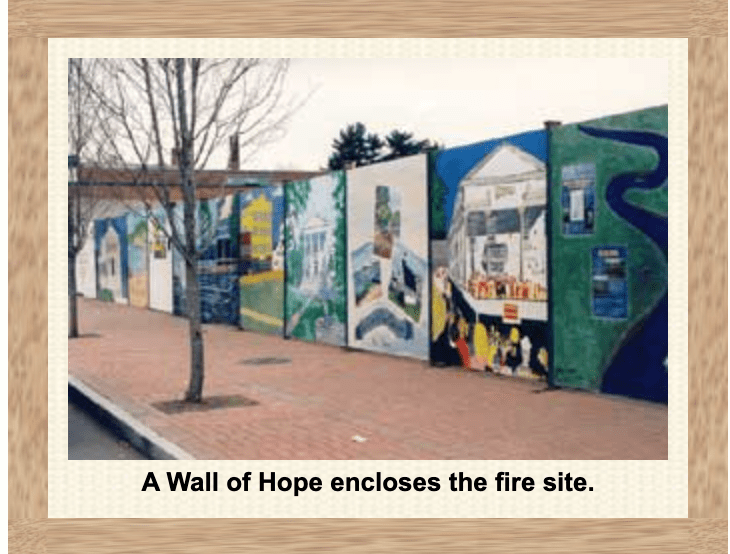 Colorful mural titled 'A Wall of Hope' surrounds a fire site outdoors.